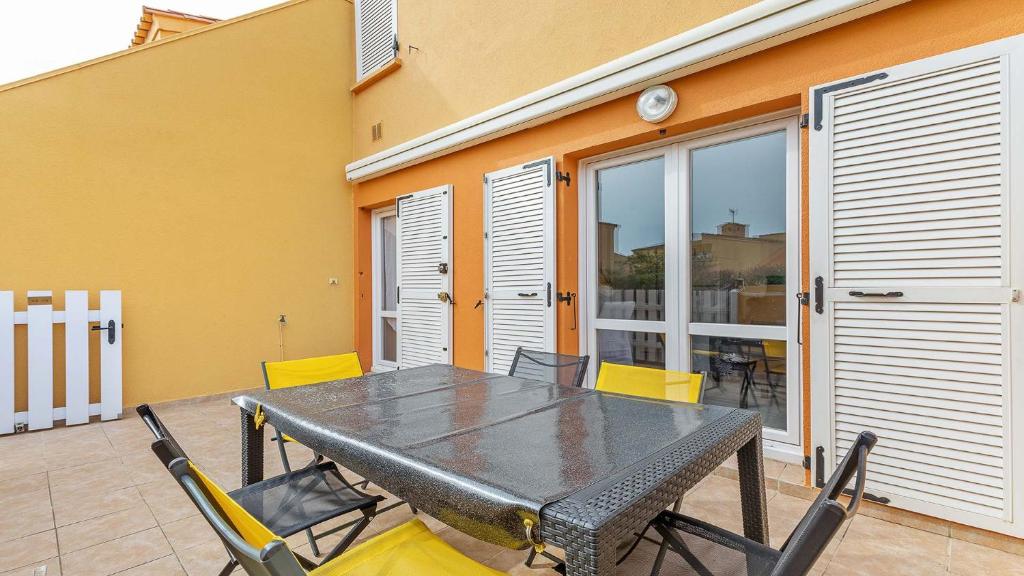 une table noire et des chaises sur une terrasse dans l'établissement Les 4 Soleils- 174- Appart moderne 4 pers, au Cap d'Agde