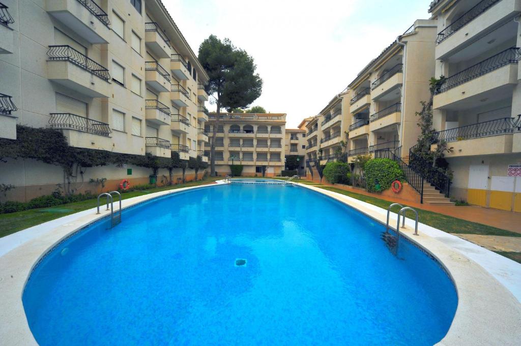 a large blue swimming pool in front of some apartment buildings at PLAYAMAR ORANGECOSTA 1 dormitorio in Alcossebre