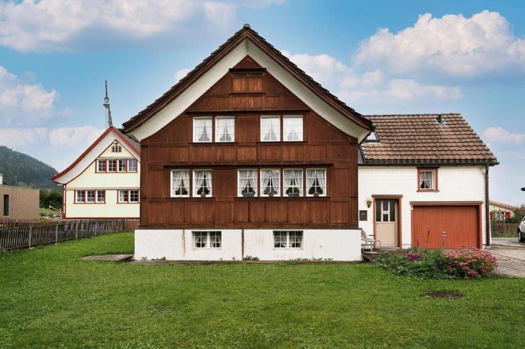 a large wooden house with a green yard at Ferienhaus Wühre in Appenzell