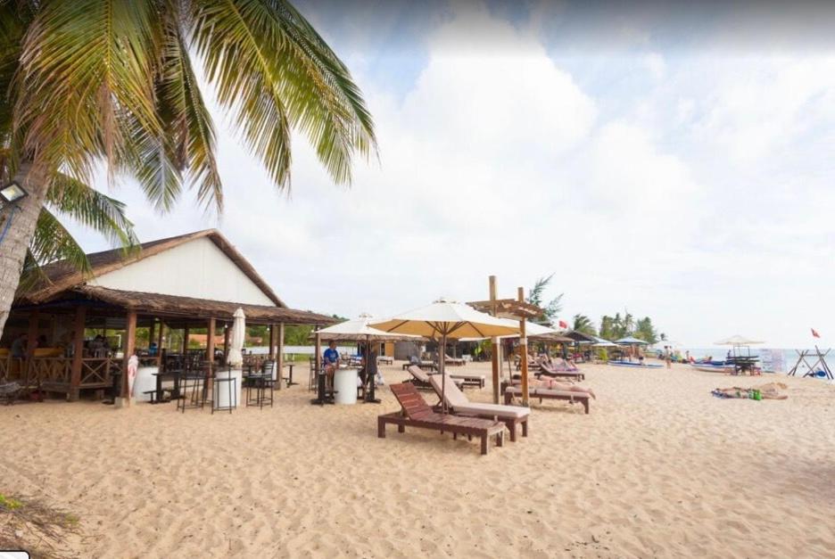 einen Strand mit Liegestühlen und Sonnenschirmen auf dem Sand in der Unterkunft Phu Long Resort & Bar Phu Quoc in Phu Quoc