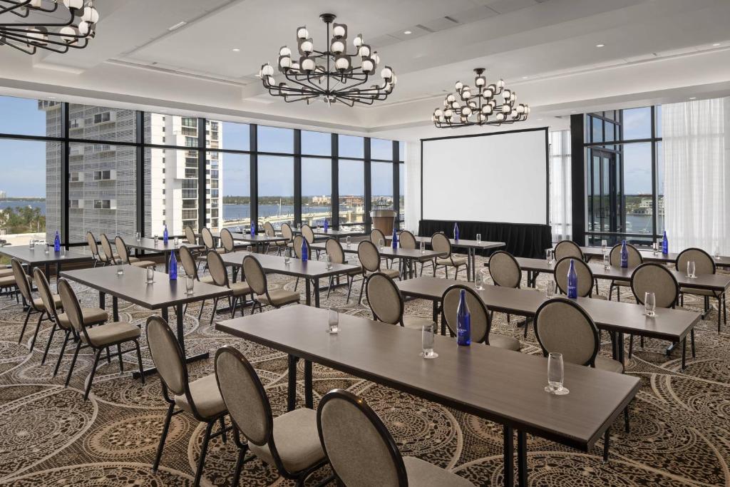 a conference room with tables and chairs and a projection screen at The Ben, Autograph Collection in West Palm Beach