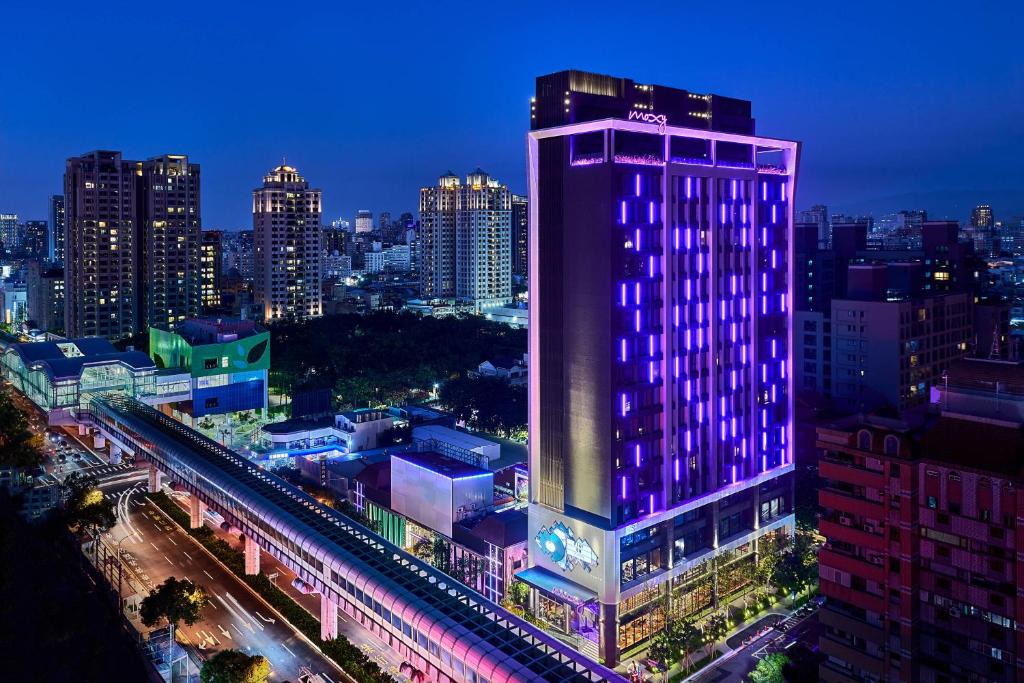 a lit up building in a city at night at Moxy Taichung in Taichung