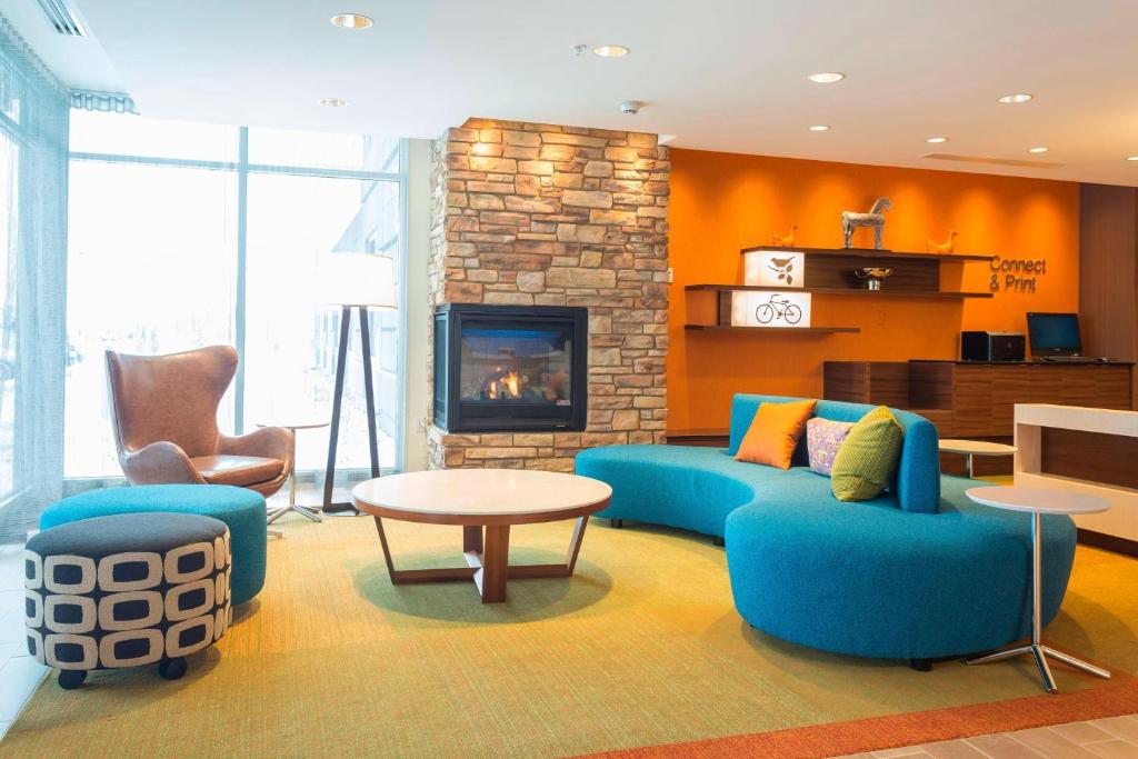 a living room with a blue couch and a fireplace at Fairfield Inn & Suites by Marriott Jamestown in Jamestown
