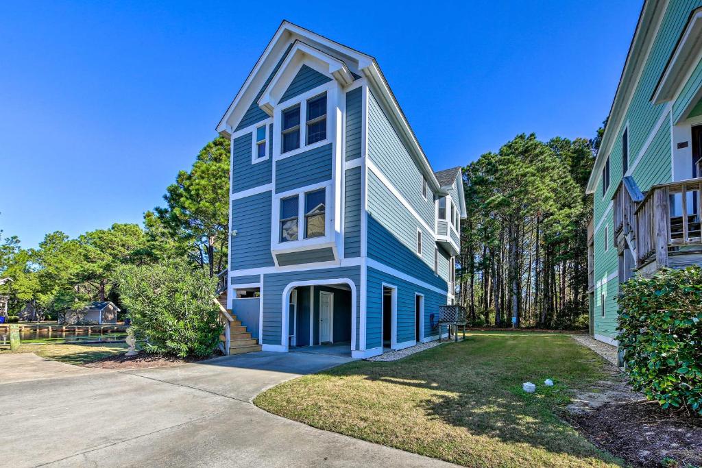 a blue and white house with a driveway at Coastal Home with Community Pool Less Than 2 Miles to Beach! in Corolla