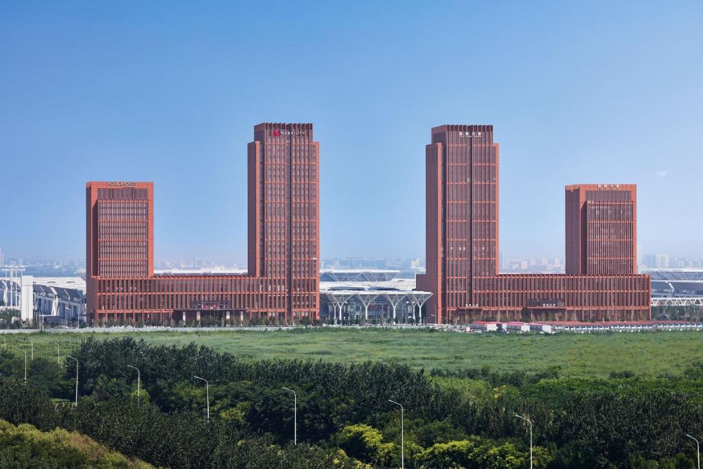 un gruppo di edifici alti di colore rosso in un campo di Four Points by Sheraton Tianjin National Convention and Exhibition Center a Tianjin