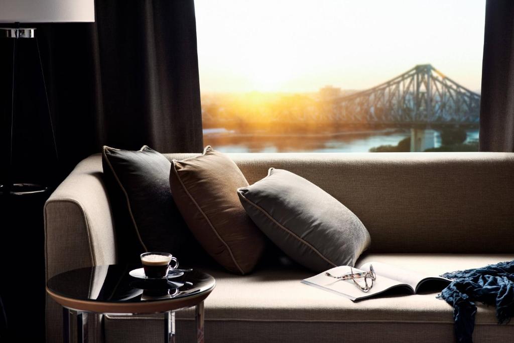 a couch with pillows and a window with a bridge at Brisbane Marriott Hotel in Brisbane