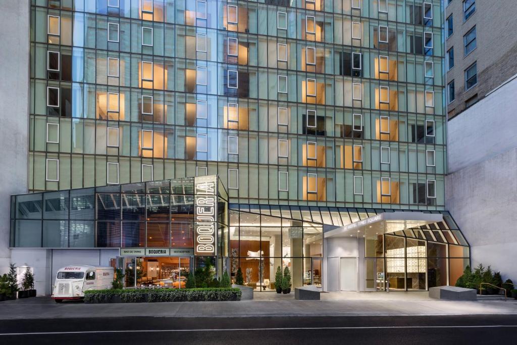 a large glass building with a van in front of it at AC Hotel by Marriott New York Times Square in New York