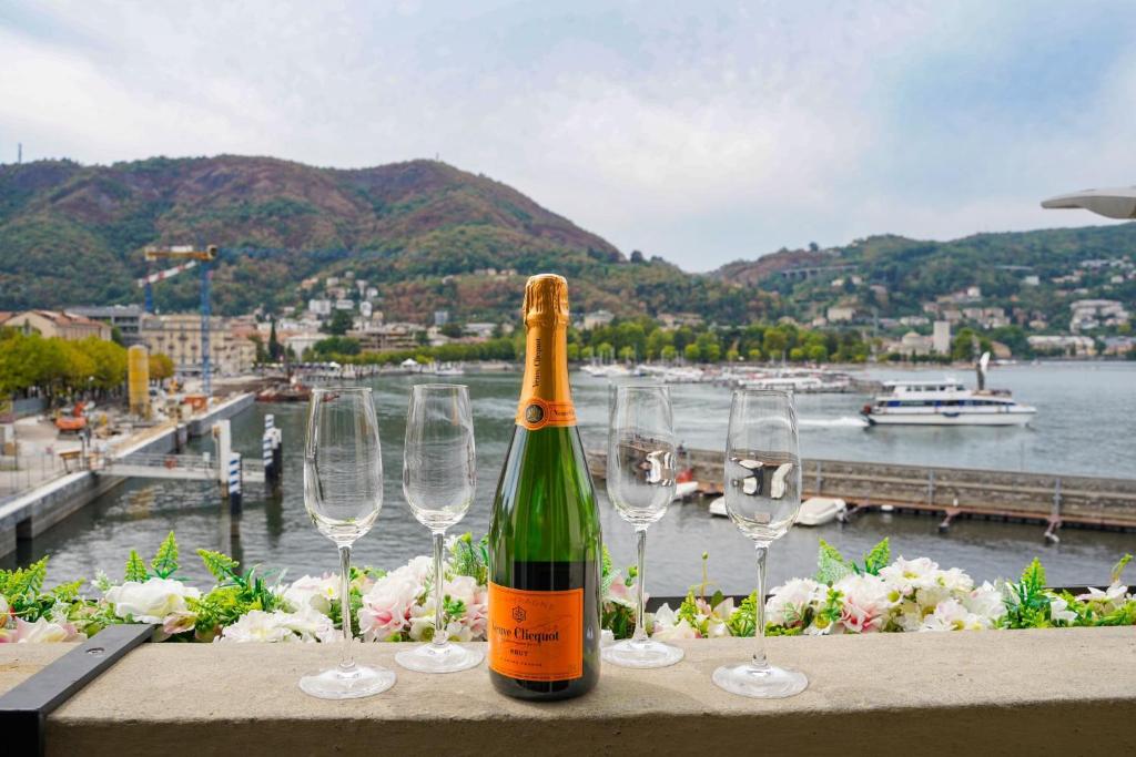 una botella de vino sentada en una mesa con copas de vino en Appartamento esclusivo fronte lago, in centro a Como con garage, en Como