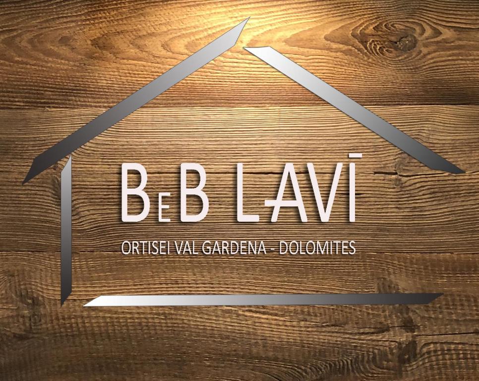 B&B Lavi Ortisei val Gardena في أورتيساي: طاولة خشبية عليها لافتة تقرأ berkan