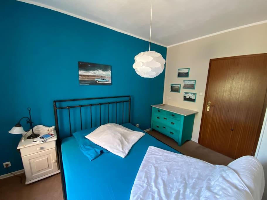ein blaues Schlafzimmer mit einem Bett und einer blauen Wand in der Unterkunft Apartment mit romantischem Garten an der Märchenstraße! in Reinhardshagen