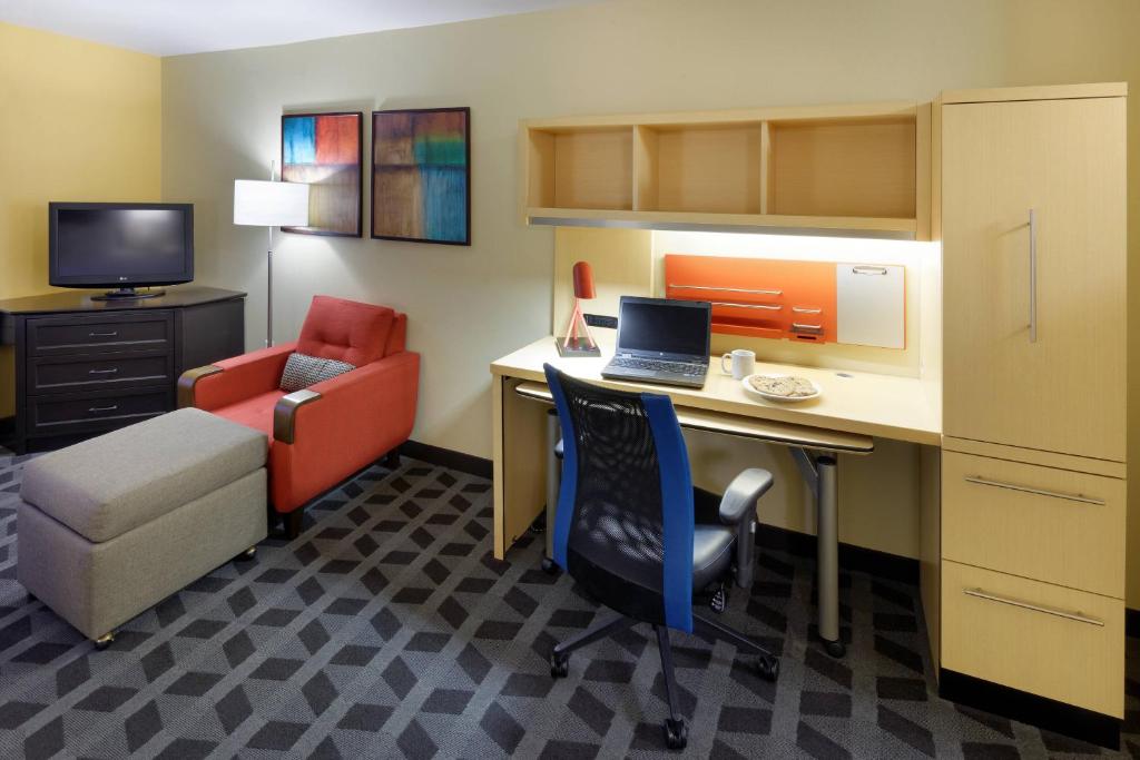 a room with a desk with a laptop and a chair at TownePlace Suites Joplin in Joplin