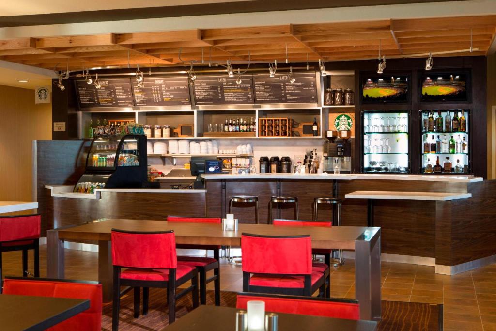 a restaurant with tables and chairs and a bar at Courtyard by Marriott Dallas Midlothian at Midlothian Conference Center in Midlothian