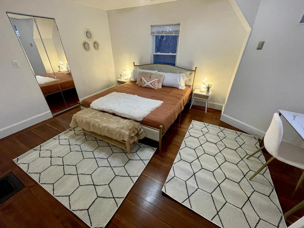um pequeno quarto com uma cama e um espelho em #23 ROOM IN THE HOUSE Newton-Wellesley Hospital 5 min walk away em Newton