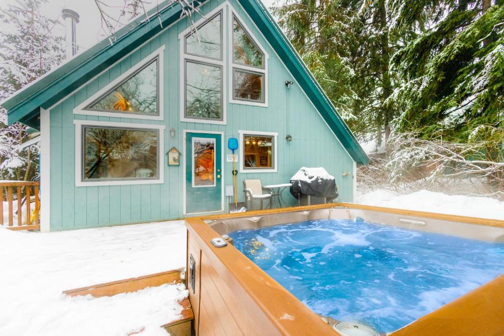 a tiny house in the snow with a hot tub at Snowbird Chalet #5 in Girdwood
