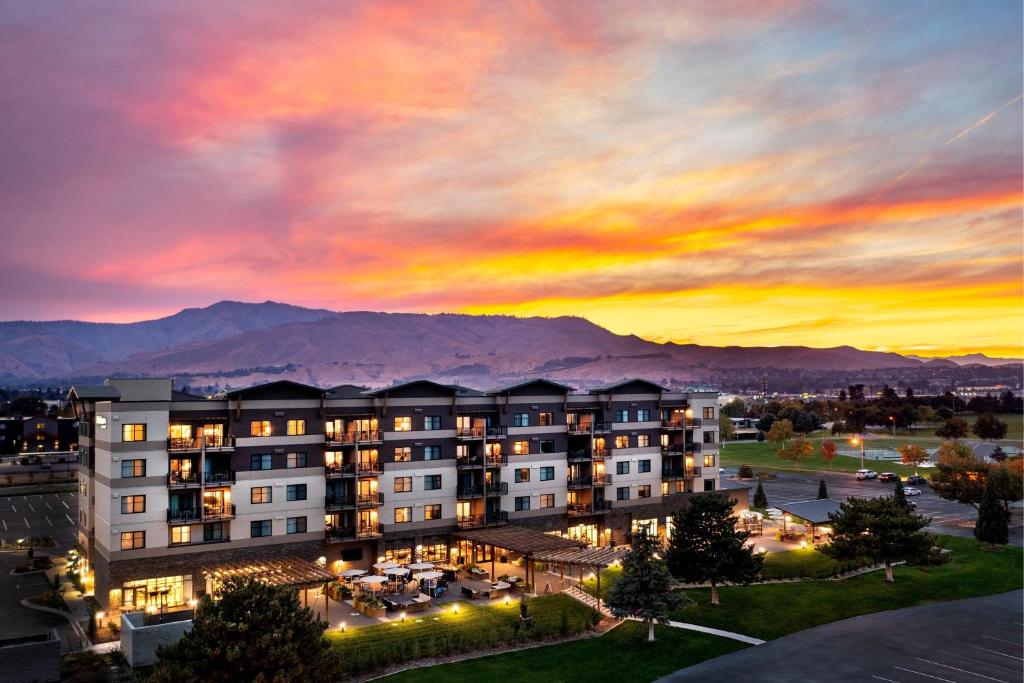韋納奇的住宿－Residence Inn by Marriott Wenatchee，享有建筑美景,背景是日落