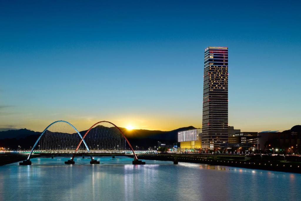 a bridge over a river with a tall building at Hotel Onoma Daejeon, Autograph Collection in Daejeon