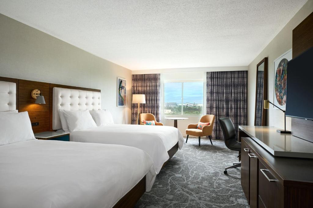 a hotel room with two beds and a television at Renaissance Meadowlands Hotel in Rutherford