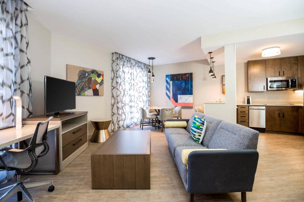 uma sala de estar com um sofá e uma televisão em Residence Inn by Marriott Dallas Frisco em Frisco