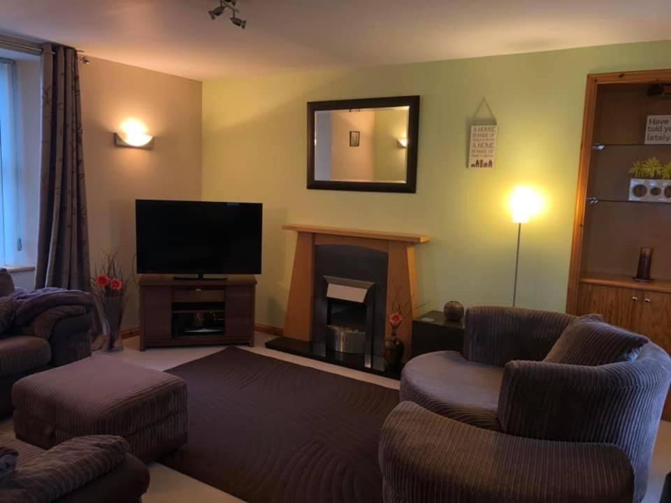 sala de estar con TV y chimenea en Stay Kirkwall Apartments - Ayre Road, en Kirkwall