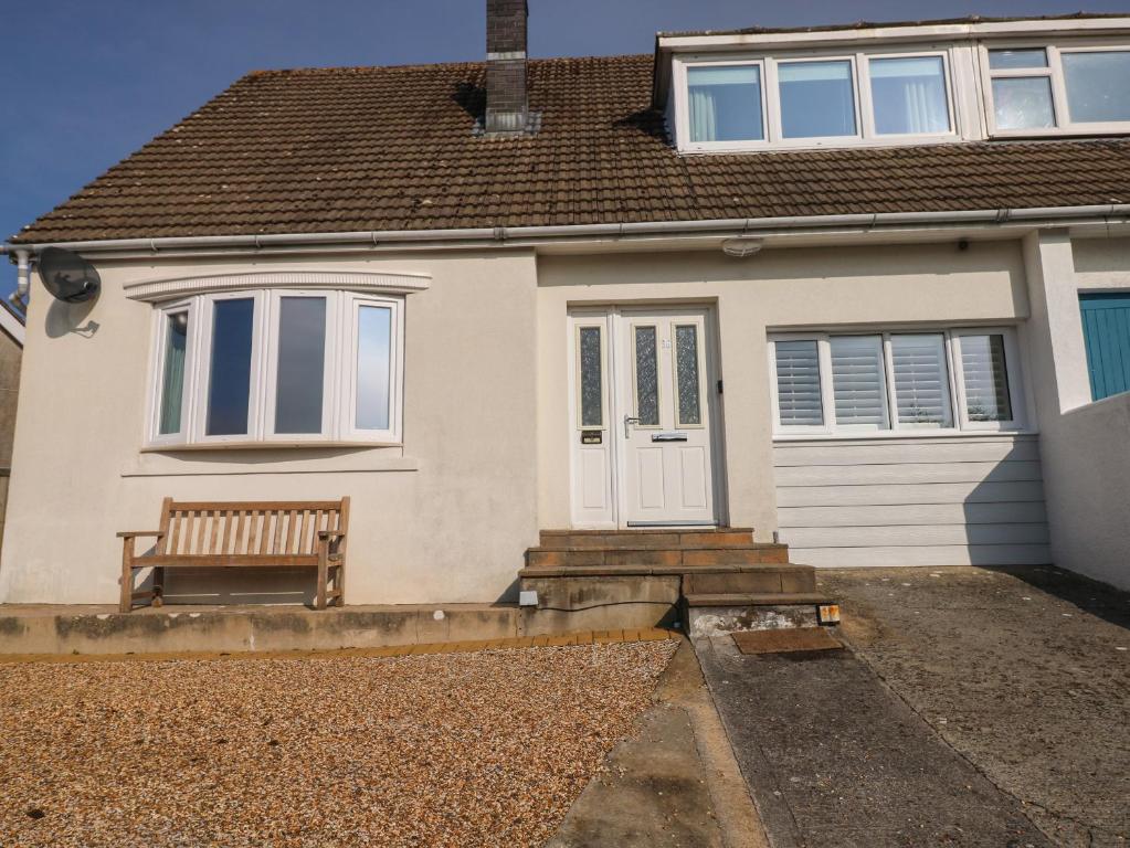 a house with a bench in front of it at Sandtop in Tenby
