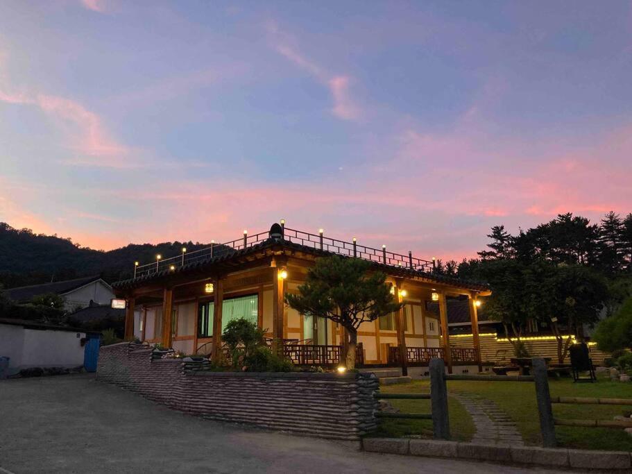 uma casa com um pôr-do-sol ao fundo em SeoAk YeonGa em Gyeongju