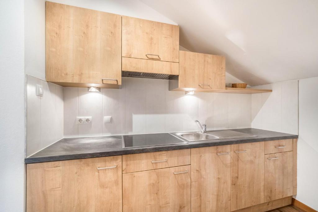 kuchnia z drewnianymi szafkami i zlewem w obiekcie Kammerhof Apartment Traube w mieście Lana