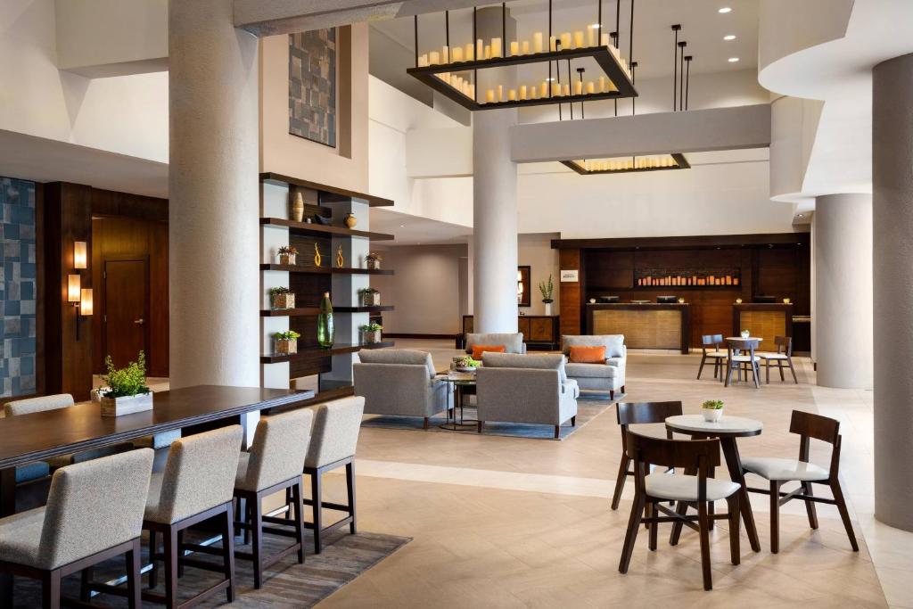 - un hall d'un hôtel avec des tables et des chaises dans l'établissement Marriott Riverside at the Convention Center, à Riverside