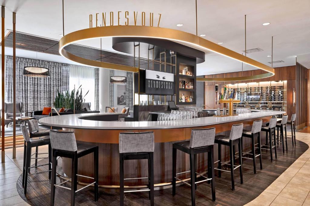 a bar in a restaurant with a bunch of stools at Courtyard by Marriott Calgary South in Calgary