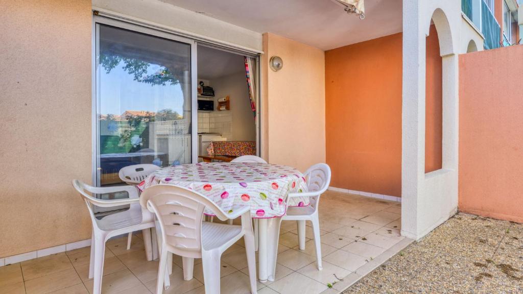 a dining room with a table and chairs at Archipel- 5B- Appart loggia - 4 pers in Cap d'Agde