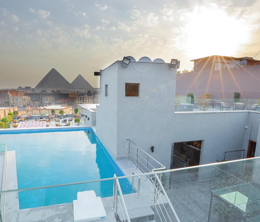 a swimming pool on the roof of a building with pyramids at Pyramid Front Hotel in Cairo