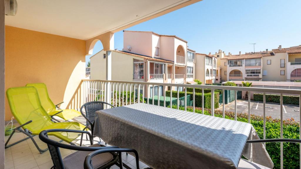 un patio avec une table et des chaises sur un balcon dans l'établissement Archipel- 10B- Appart moderne- 4 pers, au Cap d'Agde