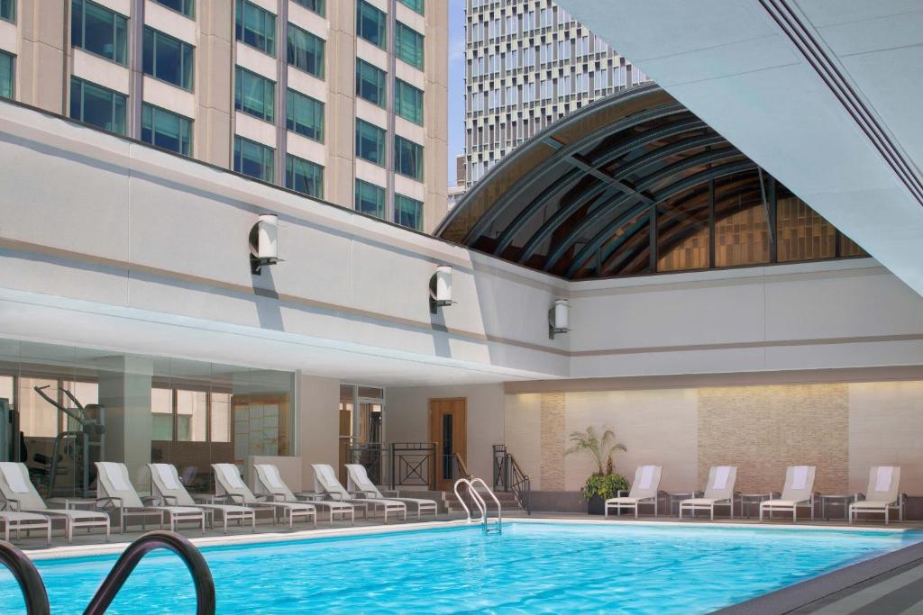 a pool in a hotel with chairs and a building at Sheraton Boston Hotel in Boston