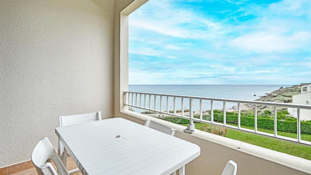 Biały stół i krzesła na balkonie z widokiem na ocean w obiekcie Les Indes Galantes- 270E- Studio vue mer- 5 pers w Cap d'Agde