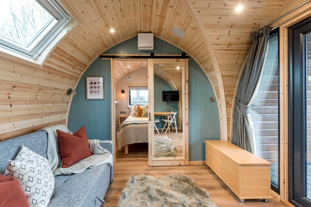 a living room with a blue couch and a window at Country Glamping in Bishop Auckland