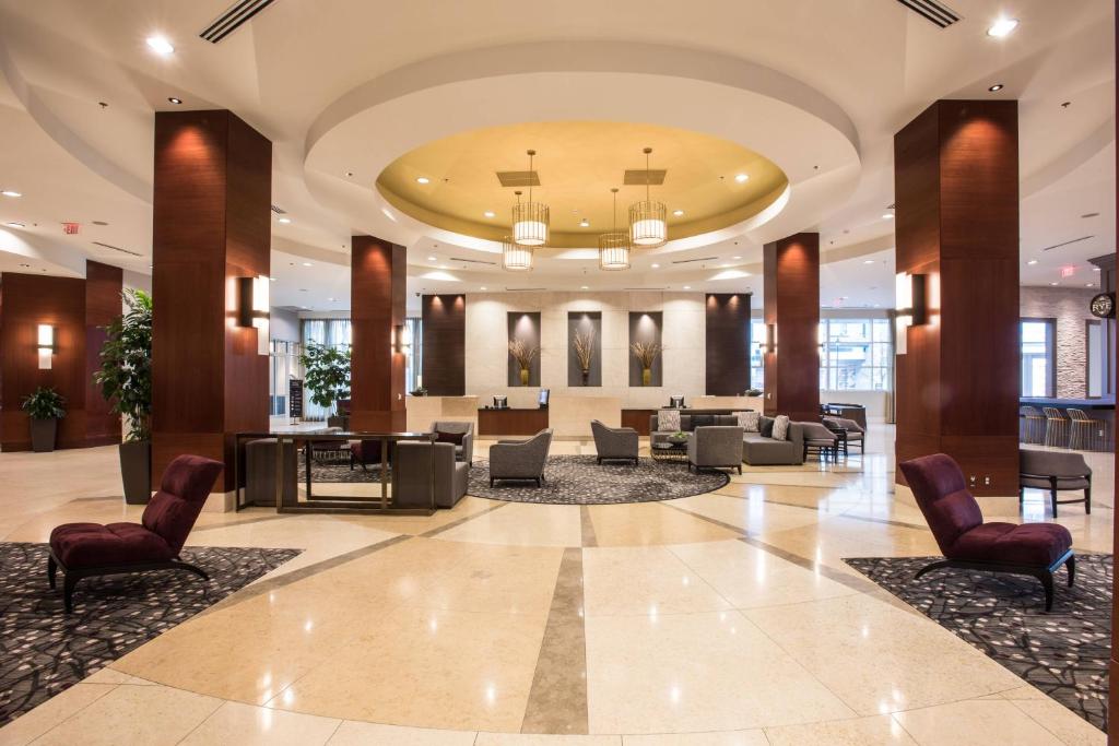 eine Lobby eines Hotels mit Stühlen und Tischen in der Unterkunft Raleigh Marriott City Center in Raleigh