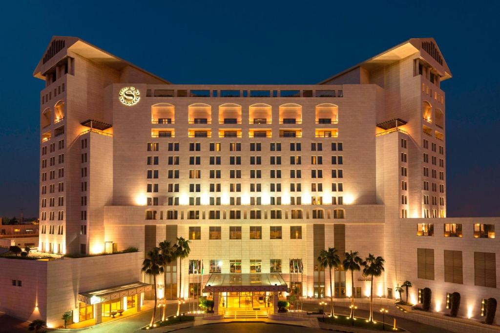 un grande edificio bianco con una torre dell'orologio di Sheraton Amman Al Nabil Hotel ad Amman