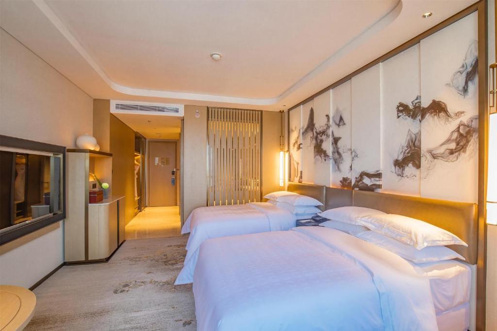 Postel nebo postele na pokoji v ubytování Sheraton Yunfu Xinxing Hotel