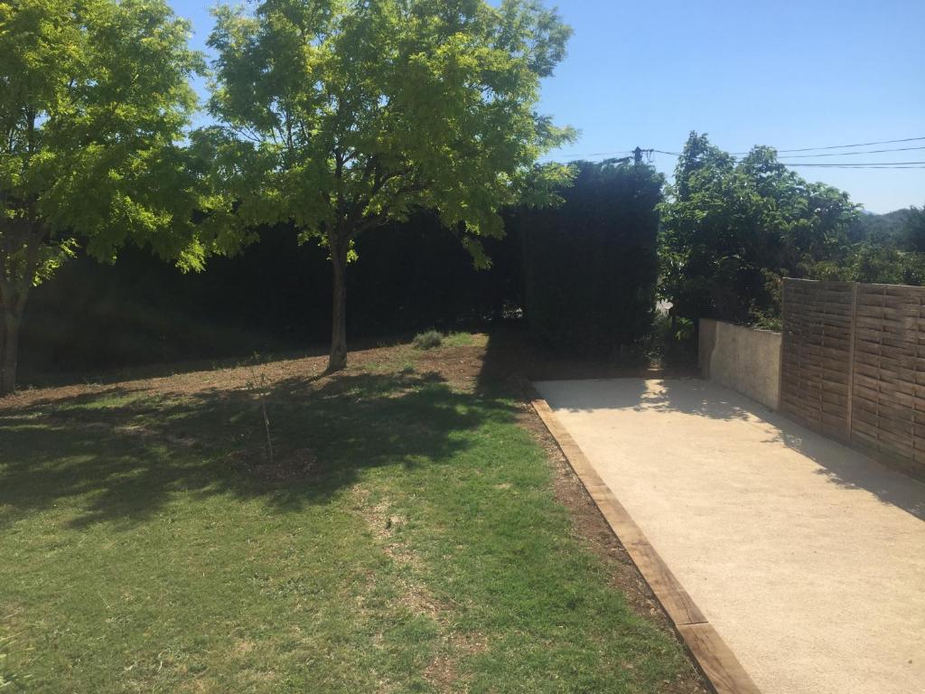 a yard with a tree and a sidewalk at Villa Emma 10 &#47; 12 personnes in Grignan