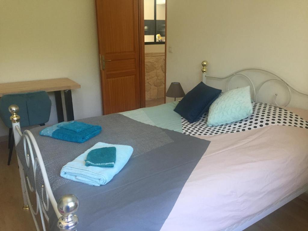 a bedroom with a bed with blue towels on it at Villa Emma 10 &#47; 12 personnes in Grignan