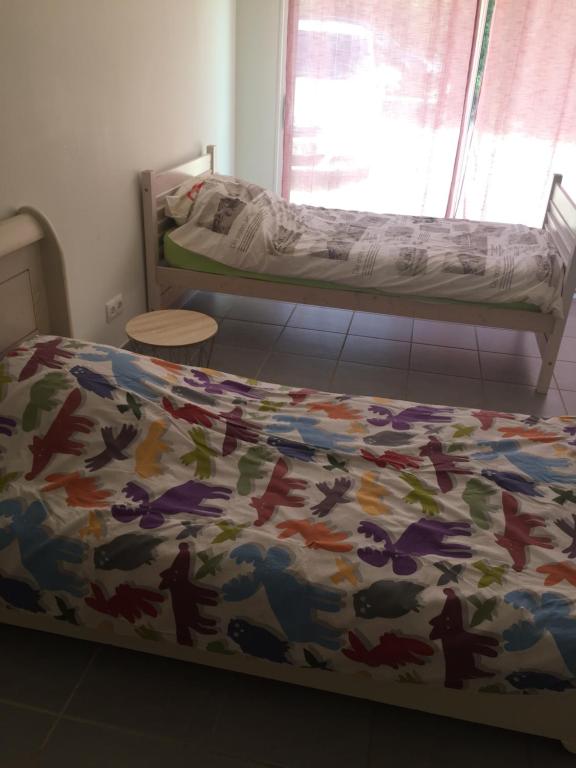 a bedroom with a bed with a colorful comforter at Villa Emma 10 &#47; 12 personnes in Grignan