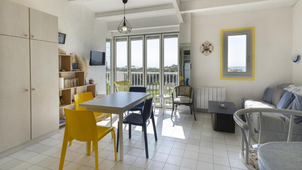 uma sala de estar e de jantar com mesa e cadeiras em Aquaplage- 105B- Studio vue mer- 5 pers em Cap d'Agde