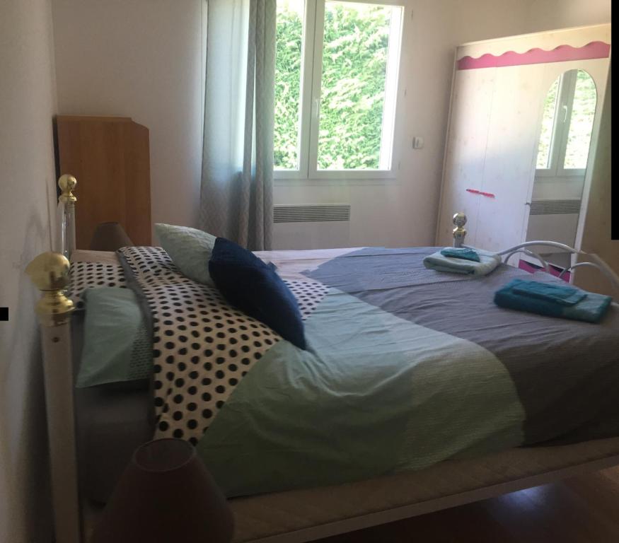 a bed with two pillows on it in a bedroom at Villa Emma 10 &#47; 12 personnes in Grignan