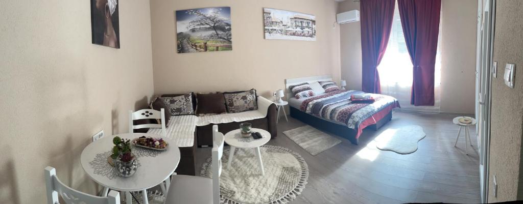 Sala de estar con cama y mesa en Apartment Downtown, en Podgorica