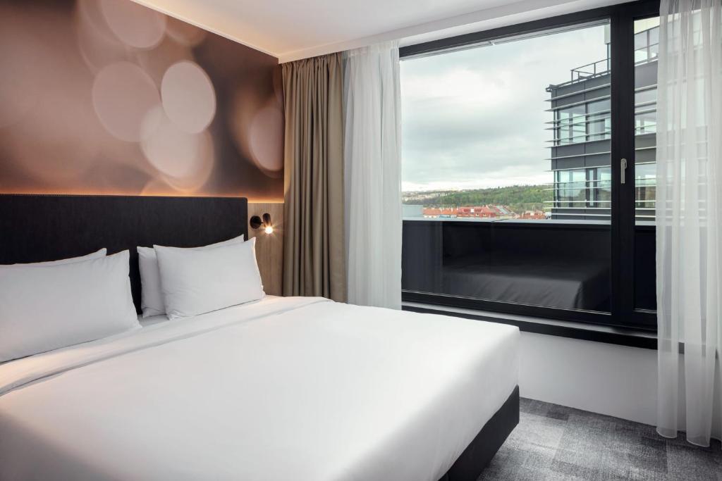a hotel room with a bed and a large window at STAGES HOTEL Prague, a Tribute Portfolio Hotel in Prague