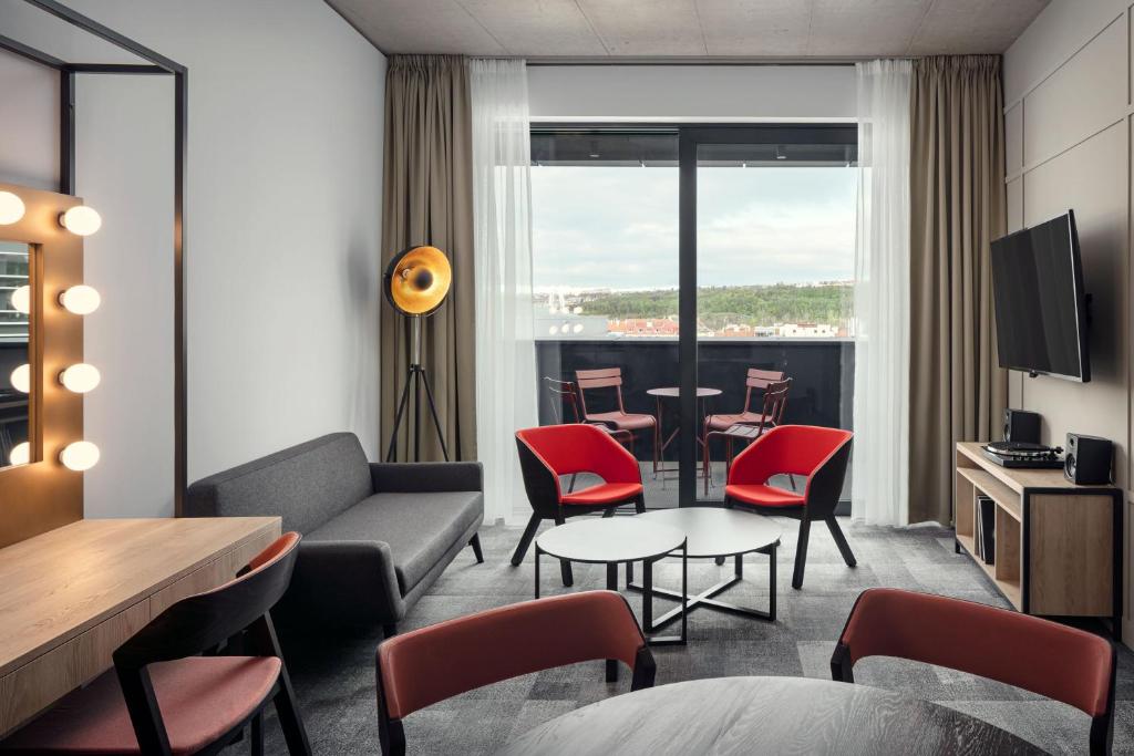 a living room with a couch and a table and chairs at STAGES HOTEL Prague, a Tribute Portfolio Hotel in Prague