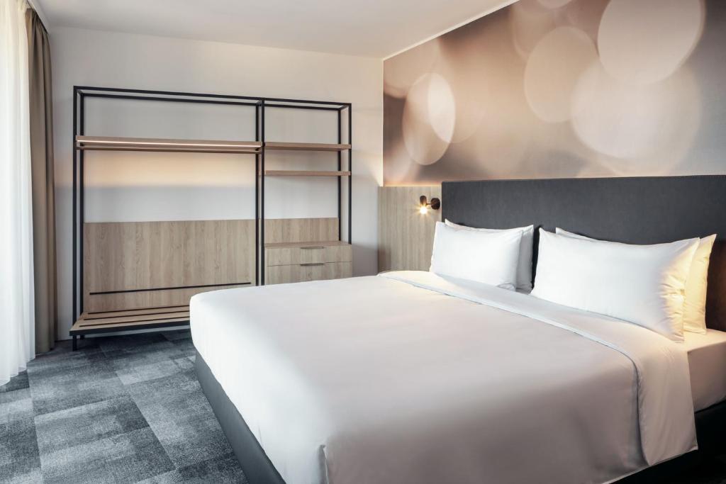 a large white bed in a hotel room at STAGES HOTEL Prague, a Tribute Portfolio Hotel in Prague