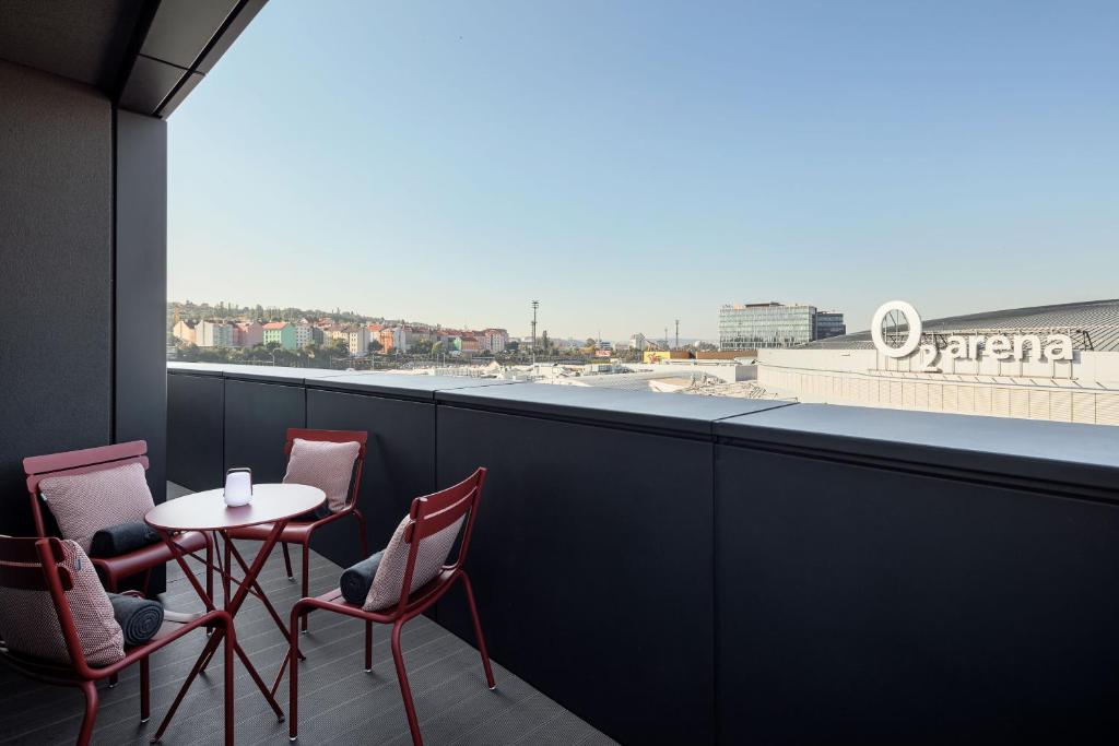 a table and chairs on a balcony with a view at STAGES HOTEL Prague, a Tribute Portfolio Hotel in Prague