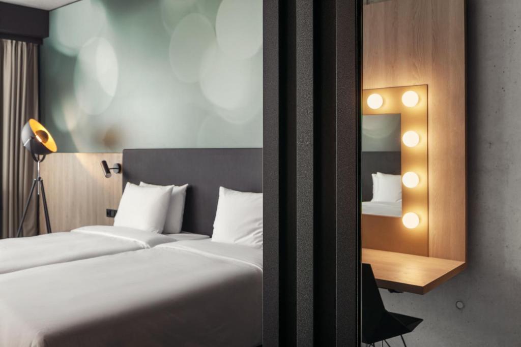 a hotel room with a bed and a mirror at STAGES HOTEL Prague, a Tribute Portfolio Hotel in Prague