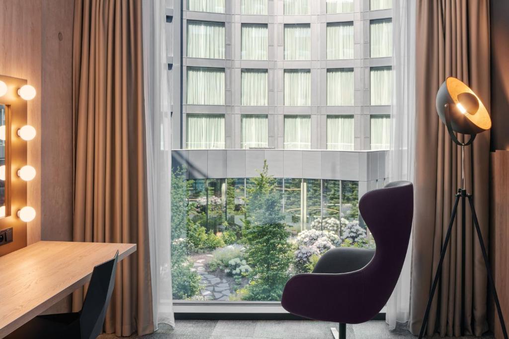 a desk and a chair in a room with a window at STAGES HOTEL Prague, a Tribute Portfolio Hotel in Prague