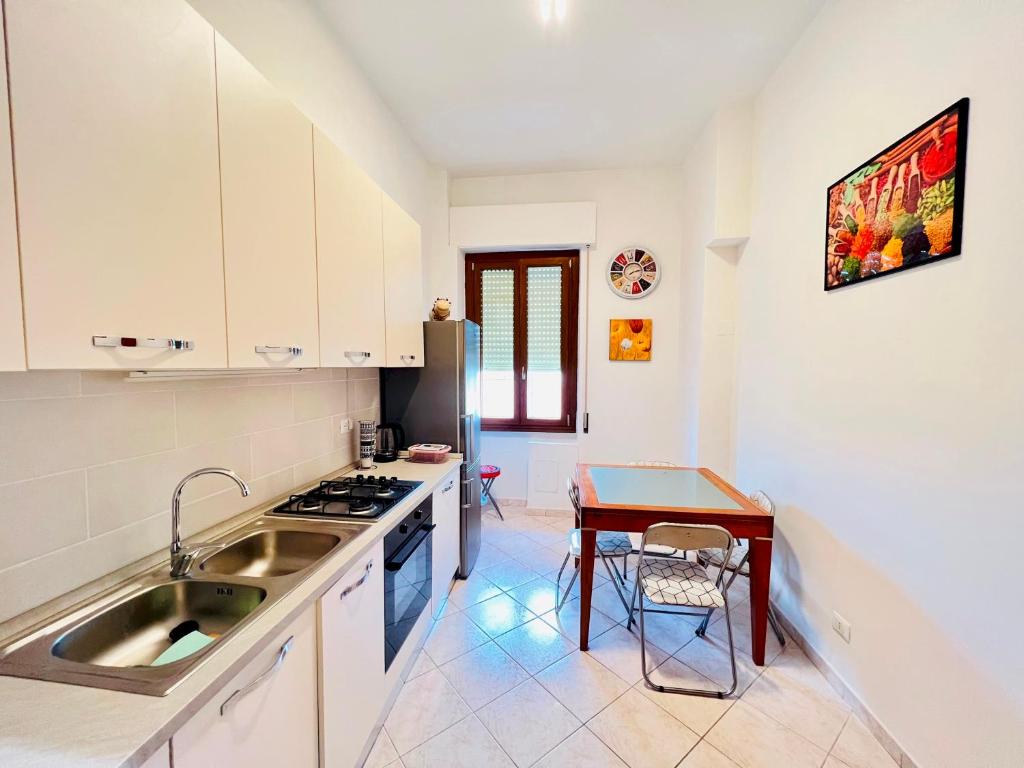 eine Küche mit einem Waschbecken und einem Tisch in der Unterkunft Be Your Home - Casa Vacanze Il Posticino in Civitavecchia